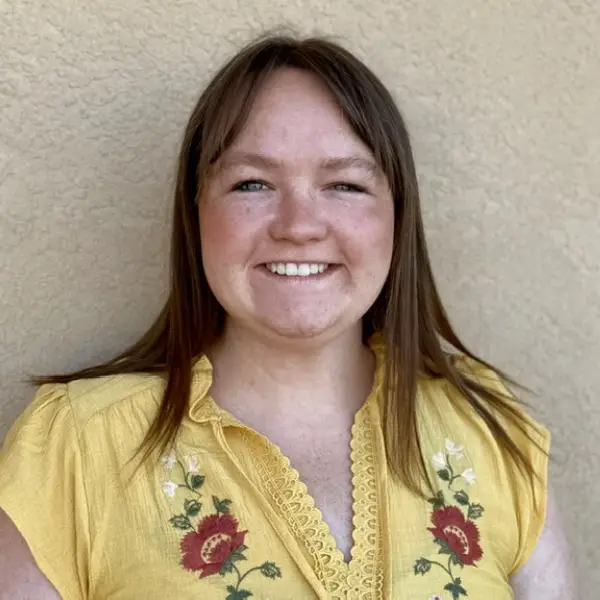 Smiling woman in yellow floral blouse outdoors